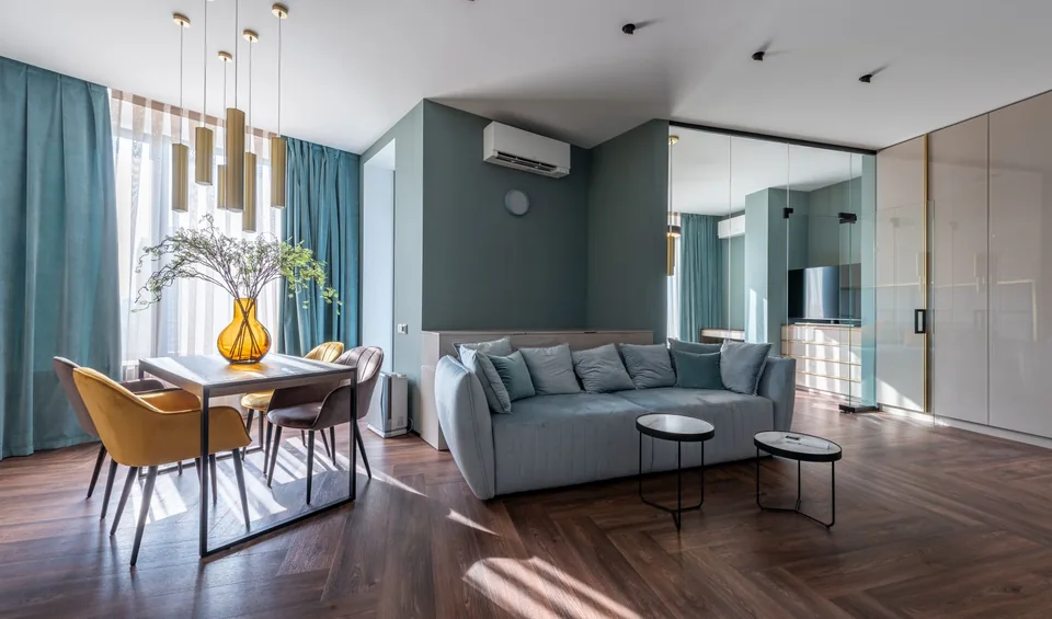 Interior residencial con sala, ventanales y acceso a otra estancia